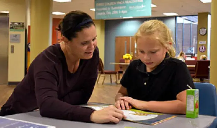 A teacher reads to a student