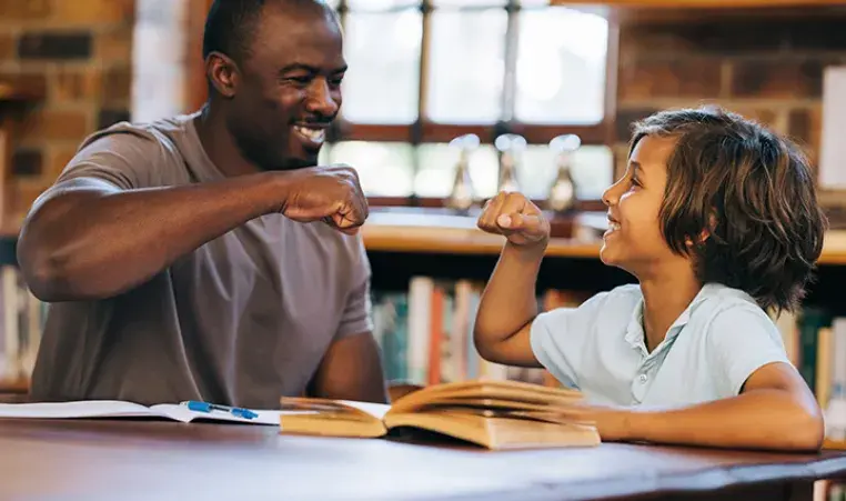 reading tutor fist bumping with kid